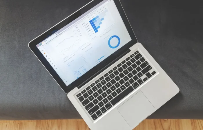 Laptop on a desk showing a data dashboard used to compare Rank Math vs Yoast results