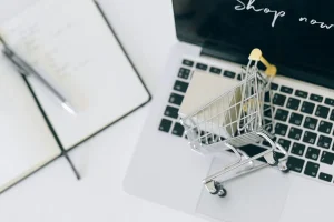 WooCommerce product page SEO: a small shopping cart on a laptop keyboard