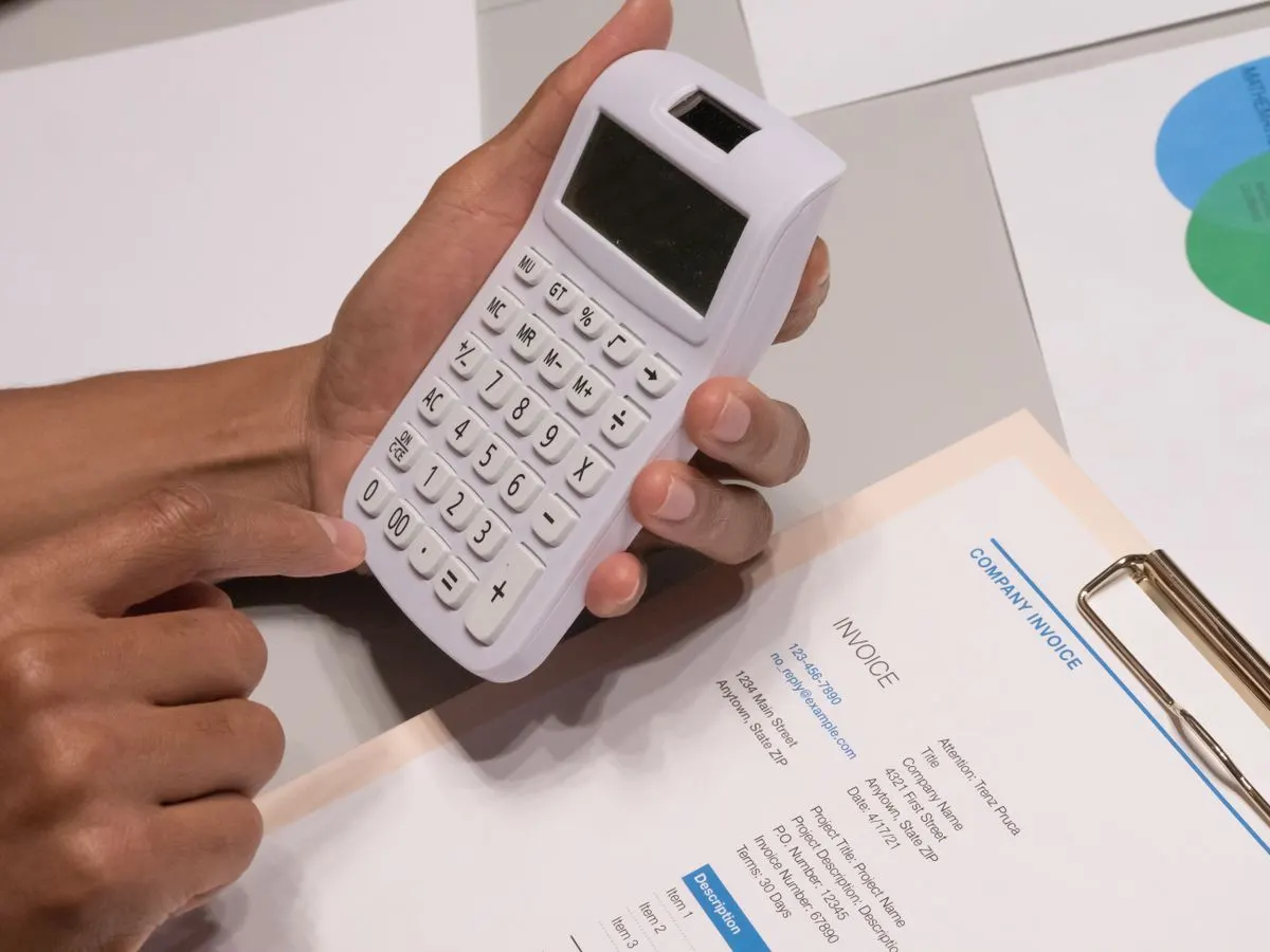 WooCommerce VAT UAE check: calculator beside a company invoice with 5% VAT