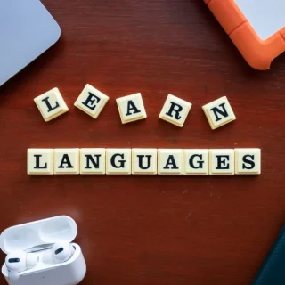 افزونه چندزبانه وردپرس؛ لپتاپ و حروف یادگیری زبانها روی میز